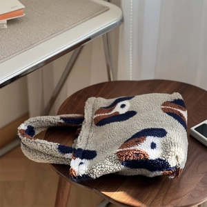 Gros plan d'un sac cabas en laine d'agneau douce avec imprimé abstrait sur tabouret