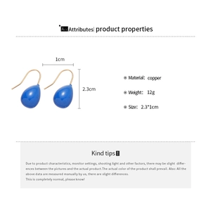 Vue détaillée de boucles d'oreilles goutte bleues avec dimensions 2,3x1cm et cuivre poli