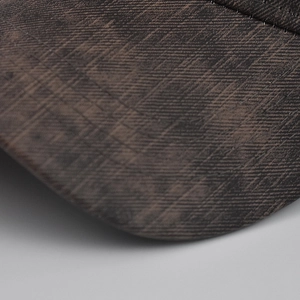 Macro view of checkered baseball cap brim showing vintage fabric texture and fine stitching