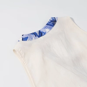 Detail of white round neck top showing blue floral print piping and soft fabric texture
