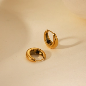 Macro view of polished 18K gold U-shaped thick hoop earrings with smooth metallic finish