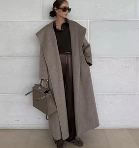 Detail of a brown double-faced camel wool coat with a stylish tie waist and lapel design