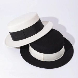 Detail view showing stacked white and black wool boater hats with contrasting ribbon bands