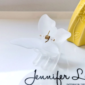 Close-up of matte white butterfly hair claw clip with durable gold metal spring detail