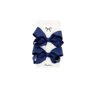 Macro detail of navy blue grosgrain ribbon bows on a white display card in a 2-piece set