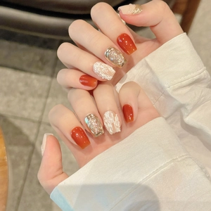 Short square pumpkin orange press-on nails with gold glitter and white marble texture