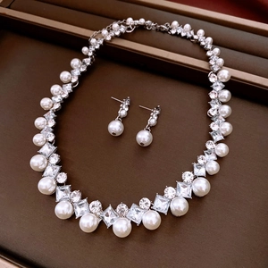 Detailed view of vintage pearl and crystal jewelry set in a brown velvet display box