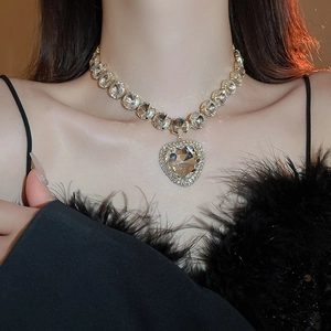 Close-up of luxury gold heart necklace set with sparkling rhinestones on model