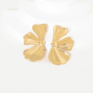 Chunky gold flower stud earrings with polished metallic petals on a white stand