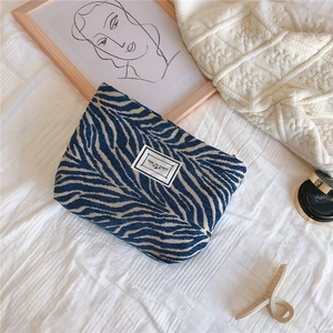 Close-up of zebra pattern chenille makeup bag with Time to Party patch on textured fabric