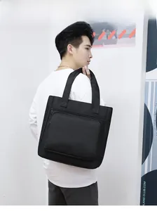 Close-up of black waterproof nylon shoulder bag featuring large front zipper pocket