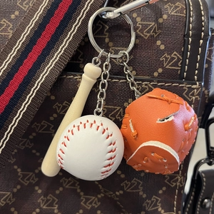 Mini baseball keychain set with wooden bat, white ball, and orange glove hanging on a bag