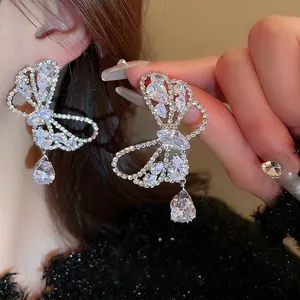 Elegant silver butterfly drop earrings with shimmering zircon crystals on a model