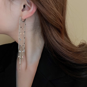 Close-up of elegant long silver tassel earrings with colorful sequins and fine chains