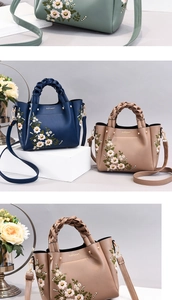 Close-up of floral embroidery detail and woven handle on the stylish PU leather handbag