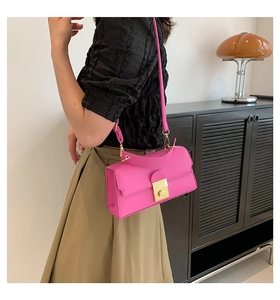 Fashionable bright pink rectangular crossbody bag with gold metal buckle shown on a model