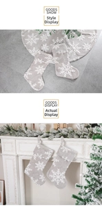 Detail view of grey plush Christmas stockings with white snowflakes hung on fireplace