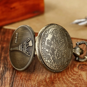 Macro detail of vintage bronze pocket watch with Paris Eiffel Tower engraving