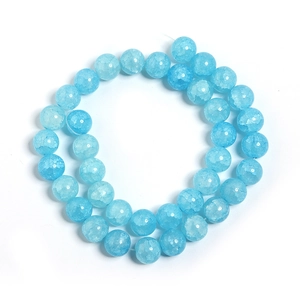Macro detail of sky blue round glass beads with a unique cracked texture for DIY jewelry