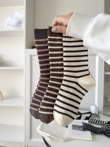 Close-up of three pairs of retro striped crew socks in vintage brown and cream shades
