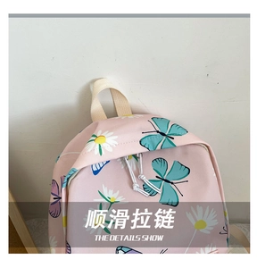 Close-up of smooth white double zippers on a pink backpack with butterfly and daisy patterns