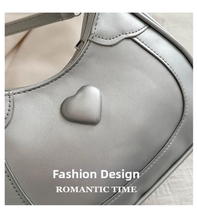 Detail of silver saddle bag showing a 3D heart-shaped relief and premium leather texture