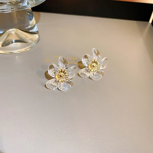 Macro view of transparent resin flower earrings with detailed golden metallic stamens