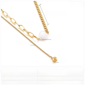 Detailed view of gold multi-layer necklace with heart shell pendant and chunky Cuban chain
