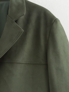 Close-up of dark green faux suede blazer showing collar detail and soft fabric texture