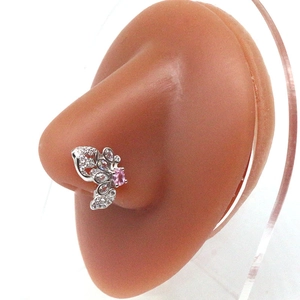 Macro shot of silver butterfly nose stud with pink crystals on a silicone model