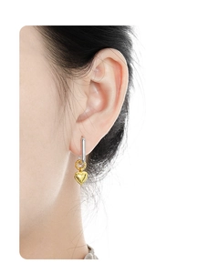 Close-up of S925 silver rectangular hoop earring with a golden heart charm on a model