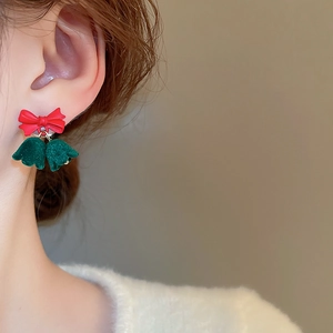 Detail of festive Christmas bow earrings with red resin and green flocked bells