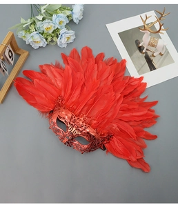 Detail of red Venetian masquerade mask with layered feathers and hollow metal base