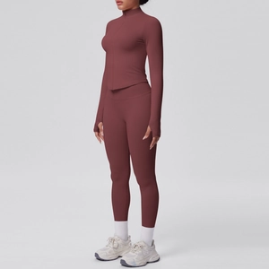 Dettaglio del set yoga rosso-marrone con giacca con zip a collo alto e fori per i pollici