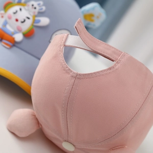 Detail of pink cotton baseball cap featuring adjustable white velcro strap for toddlers