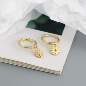 Detail of 925 sterling silver floral earrings with small diamond center and gold finish