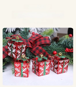 Close-up of four red Christmas gift box ornaments with glitter snowflakes and gold strings