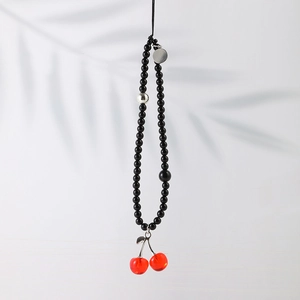 Beaded phone charm with black beads, silver accents and red cherry charms on light gray background