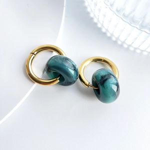 Detail of 18k gold plated hoop earrings with dark green marble textured stone charms