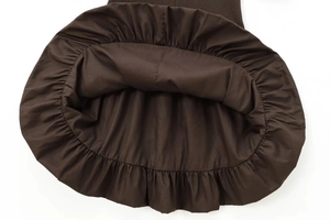 Detailed view of dark brown dress hem featuring elegant ruffled pleats in cotton blend