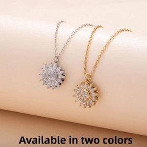 Detail view of rotating sunflower necklaces in gold and silver finishes with white zircon