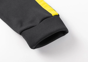 Detail of ribbed cuffs on dark grey hoodie with bright yellow side stripes