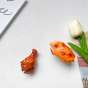 Realistic fried chicken leg and wing phone grip stand on a minimalist tabletop