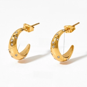 Macro shot of gold C-shaped earrings showing cubic zirconia inlay and 5mm width dimension