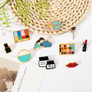Creative makeup themed pins featuring eyeshadow, lipstick and brush in colorful enamel