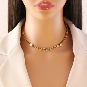 Golden stainless steel necklace with white and green star pendants on a model neck