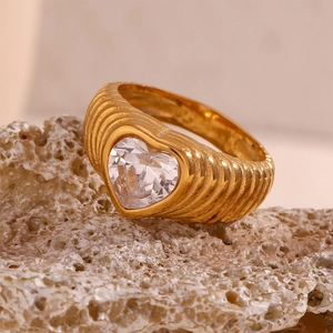 Macro shot of 18K gold plated ring with wave texture and clear heart-shaped zircon stone