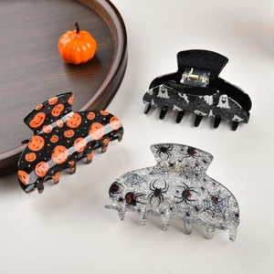 Halloween hair claw clips set featuring pumpkin ghost and spider patterns on dark wood