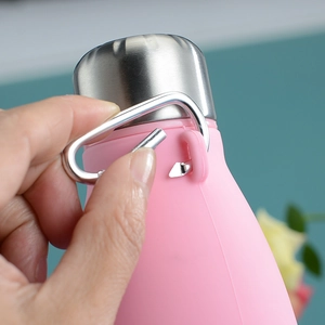 Close-up of stainless steel carabiner and cap on pink collapsible silicone water bottle