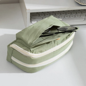 Detailed side view of light green multi-layer canvas pencil case with three zip pockets
